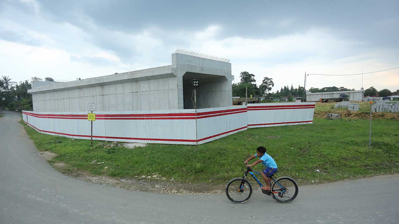 MAKIN TAMPAK: Warga melintas di kawasan pembangunan tol, Sanggrahan, Tirtoadi, Mlati, Sleman, kemarin (30/1). Proyek pembangunan tol Jogja-Bawen Seksi I sepanjang 8,8 Km terus dikebut. Ditargetkan tol beroprasi tahun 2024. (ELANG KHARISMA DEWANGGA/RADAR J