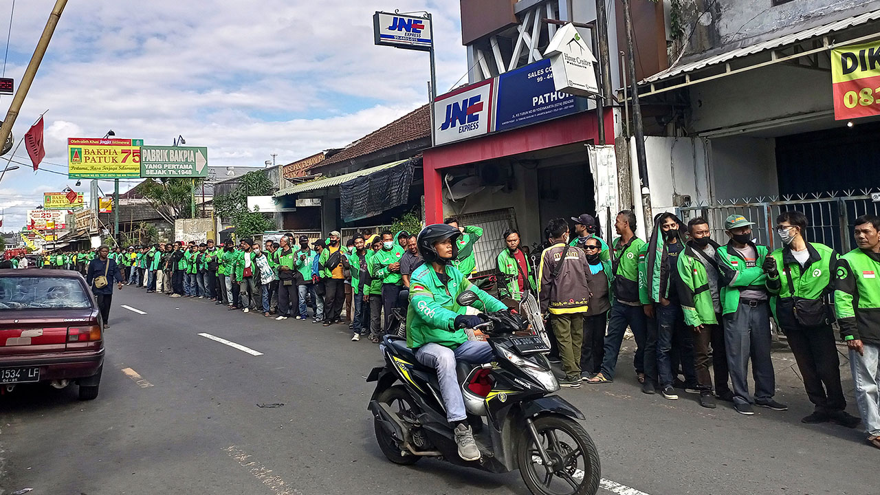 MENGULAR: Para pengemudi ojek online (ojol) antre untuk mendapatkan sedekah yang dibagikan oleh salah satu produsen bakpia pathok, di Jalan KS Tubun, Kota Jogja, kemarin (11/4). Sedekah tersebut guna membantu sebagian masyarakat dalam memenuhi kebutuhan j
