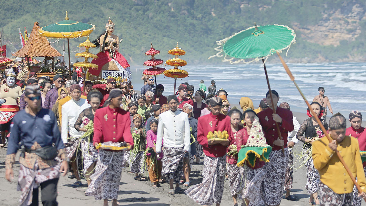 UPACARA ADAT: Warga Mancingan mengarak patung Dewi Sri saat prosesi Bekti Pertiwi Pisungsung Jaladri di pesisir pantai Parangkusumo, Bantul kemarin (23/5). Kegiatan ini digelar sebagai ungkapan rasa syukur warga atas melimpahnya panen raya. ELANG KHARISMA