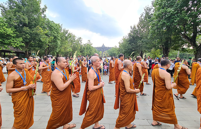 LAKU SPIRITUAL: Para umat Buddha mengikuti prosesi berjalan dari Candi Mendut menuju Candi Borobudur sebagai penutup rangkaian Indonesia Tipitaka Chanting dan Asalha Mahapuja 2567 BE/2023.(Naila Nihayah/Radar Jogja)