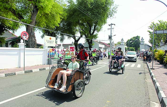 KELILING: Wisatawan mancanegara berkeliling menggunakan jasa becak motor saat melintas di Jalan Rotowijayan, Kraton, Kota Jogja, kemarin (7/8). Guntur Aga Tirtana/Radar Jogja