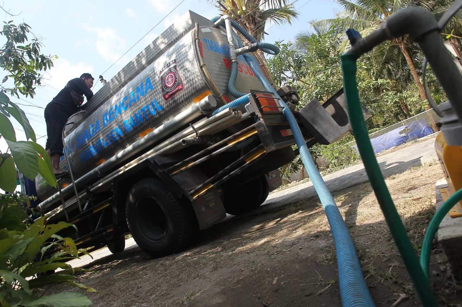 WASPADA: Petugas Tagana Dinas Sosial Bantul saat menyalurkan air bersih di Dusun Petung, Kalurahan Bangunjiwo, Kasihan, Bantul. (Guntur Aga Tirtana/Radar Jogja)