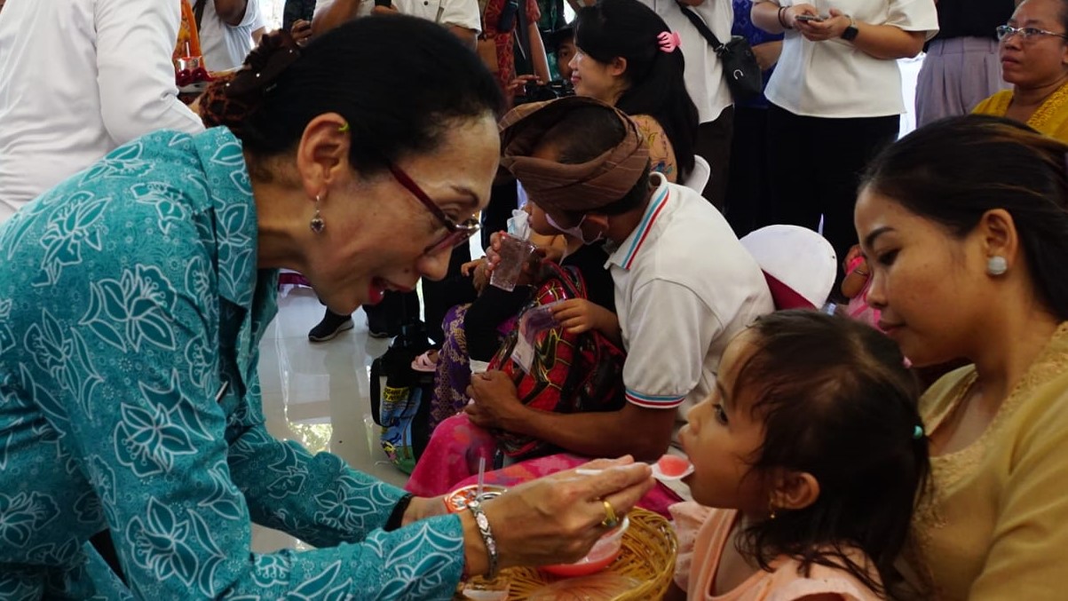CEGAH STUNTING: Pj. Ketua Tim  Penggerak PKK Kabupaten Buleleng, Ny. Paramitha Lihadnyana (kiri) saat pemberian makanan tambahan (PMT) kepada balita di Buleleng dalam rangka mencegah stunting.