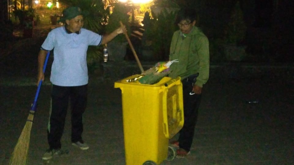 Petugas kebersihan membersihkan sampah yang berserakan di Taman Kota Singaraja pada perayaan pergantian tahun.