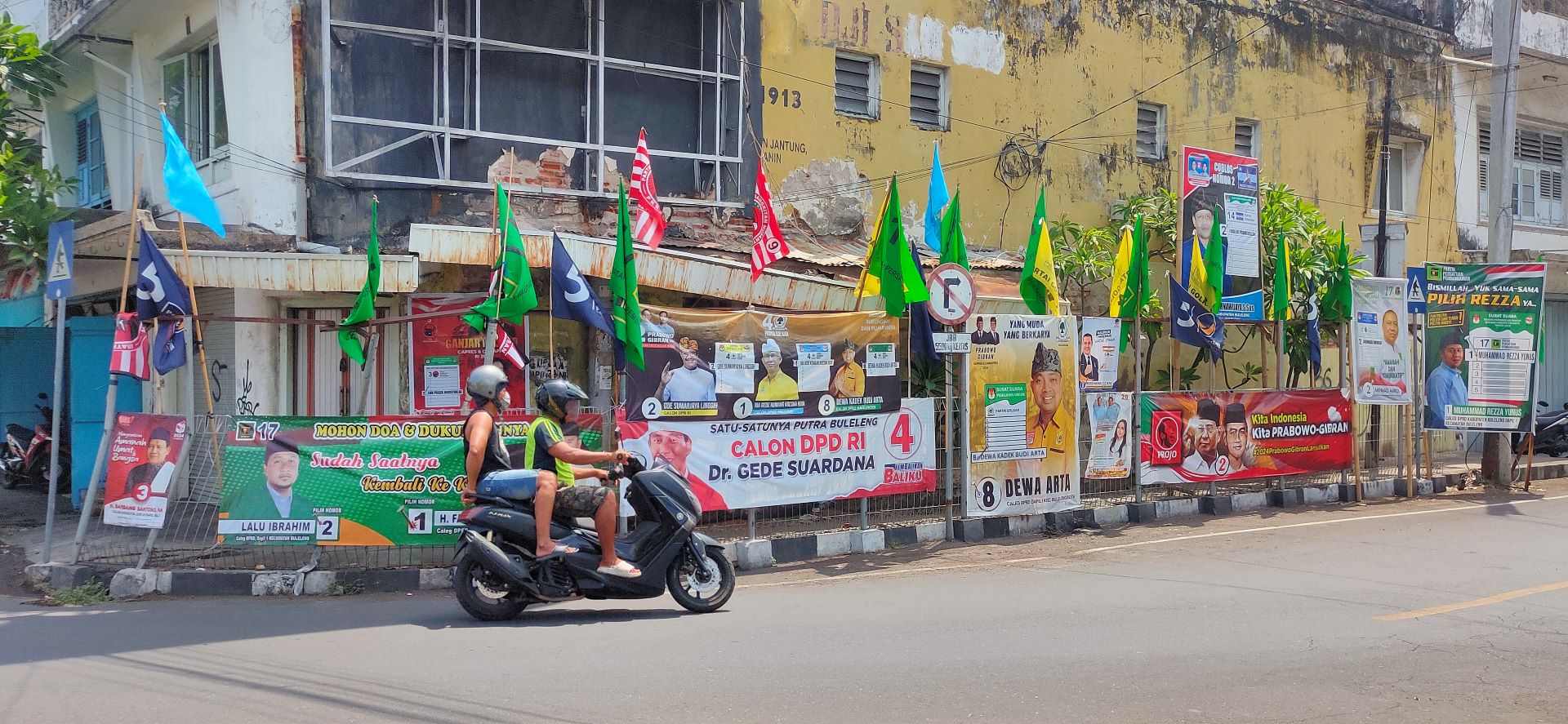 ETALASE KAMPANYE: Alat peraga kampanye milik caleg yang terpasang pada pagar pengaman pejalan kaki di Jalan Erlangga Singaraja.