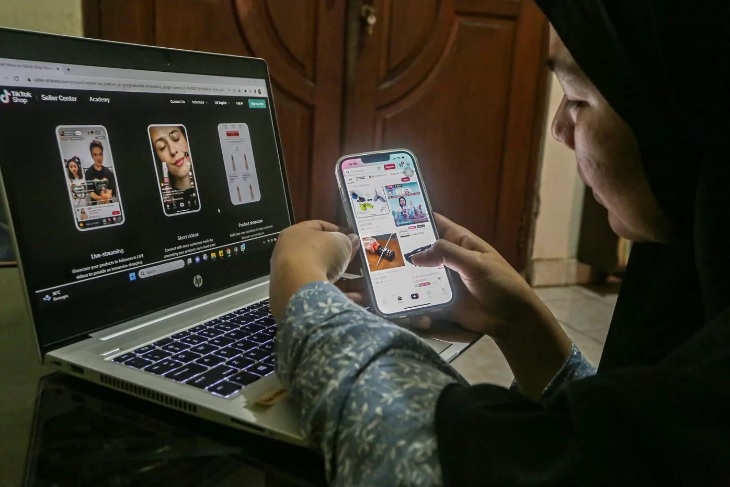 Warga melihat barang yang dijual di Tiktok shop melalui layar telepon genggam di Depok, Jawa Barat.