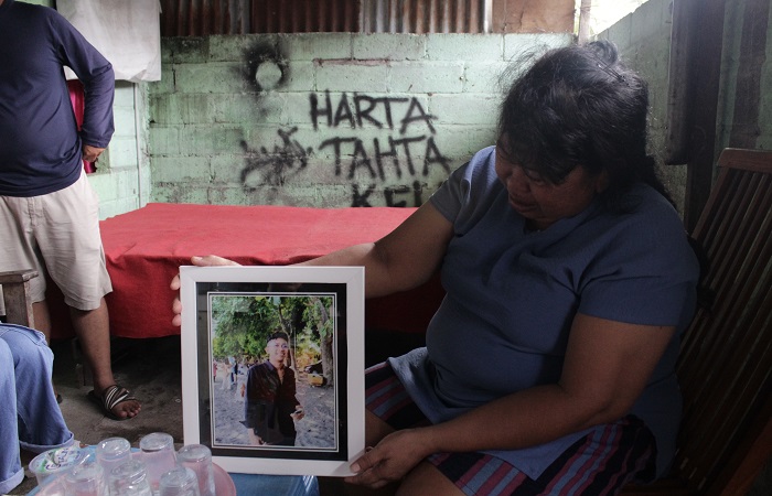 Putu Suartini memegang foto anaknya Adhi Putra Krismawan. Korban merupakan anak paling disayang ibunya. Korban tewas dikeroyok dan ditikam senjata tajam hingga tewas di Dalung, Badung, Bali.