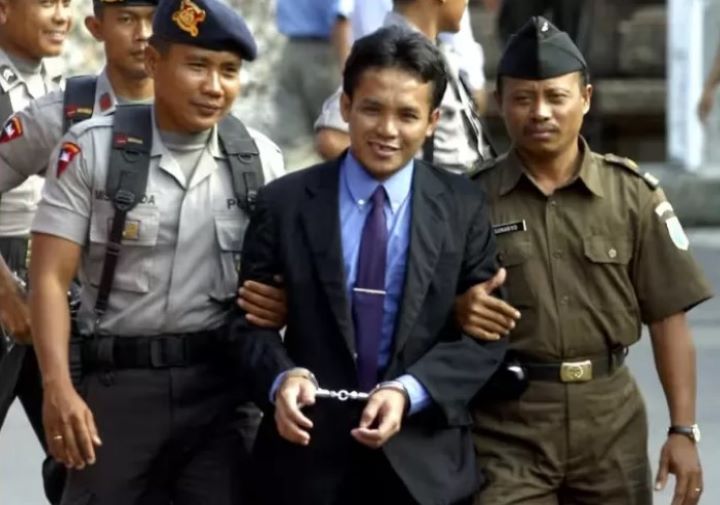Ali Imron dikawal oleh polisi Indonesia di Bali pada tahun 2003.