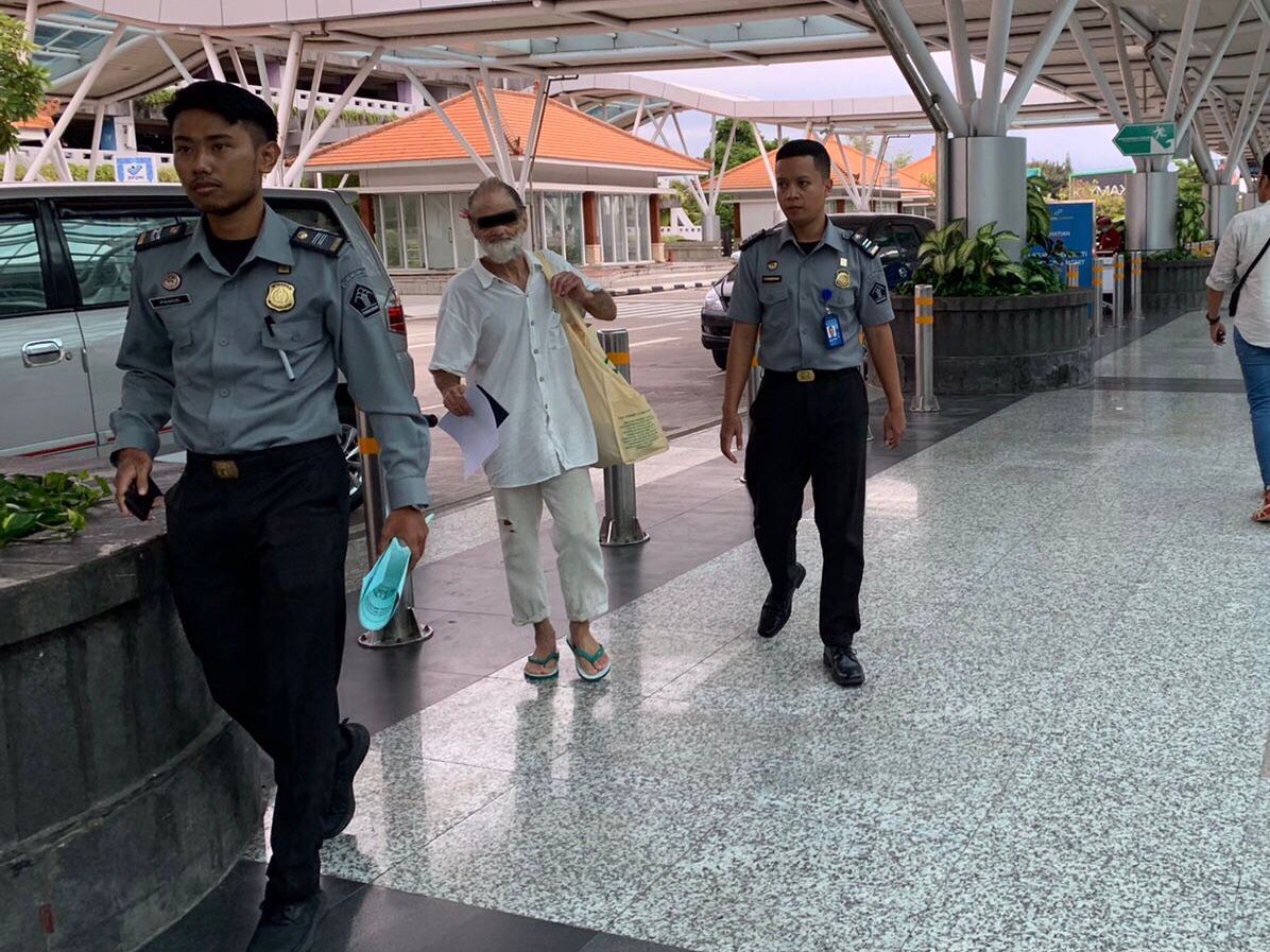 DEPORTASI: WNA asal Amerika Serikat berinisial MAM (pakai baju putih) saat menjalani proses deportasi melalui Bandara I Gusti Ngurah Rai.
