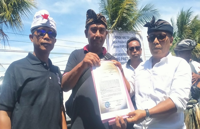 Ketua Forum Perbekel Terdampak Jalan Tol Mengwi-Gilimanuk I Nyoman Arnawa didampingi Perbekel Desa Antosari I Nyoman Agus Suryawan dan warga yang menunjukkan surat kepada Presiden Jokowi.