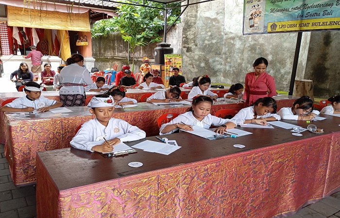 Siswa SD di wilayah Desa Adat Buleleng mengikuti lomba nyurat aksara Bali. Uniknya, salah satu pesertanya beragama Muslim.