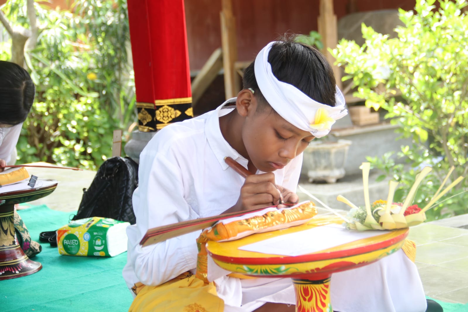 NYURAT AKSARA: Salah seorang siswa SD saat mengikuti lomba nyurat aksara Bali serangkaian Bulan Bahasa Bali di Buleleng.