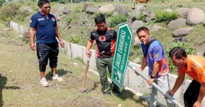 PERBAIKI RAMBU: Staf BPBD Jembrana melakukan perbaikan rambu jalur evakuasi tsunami.