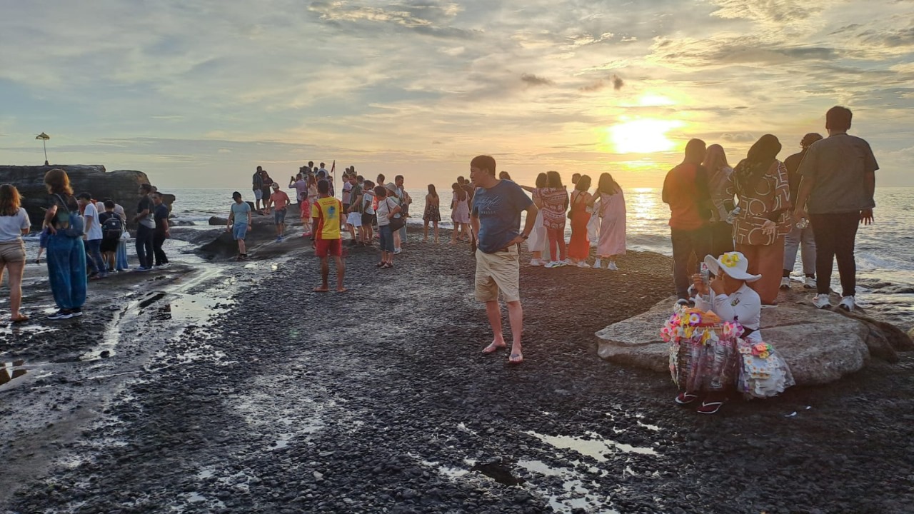ENJOY BALI: Wisatawan saat berlibur di objek wisata Tanah Lot.