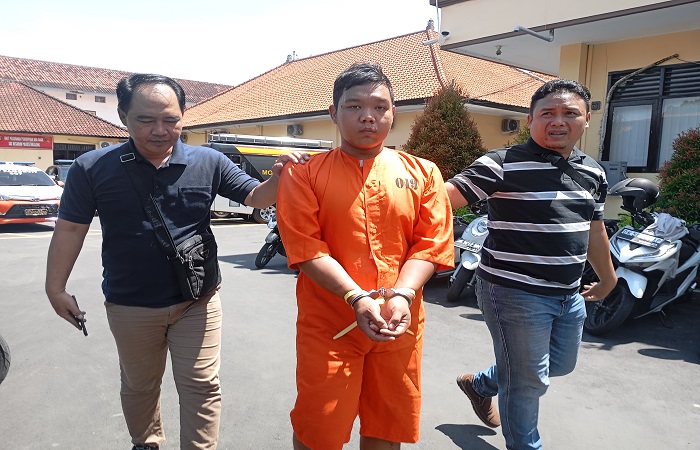 Tersangka Mang Agus dikawal polisi ke hadapan awak media. Ia merupakan residivis yang baru saja keluar dari penjara.