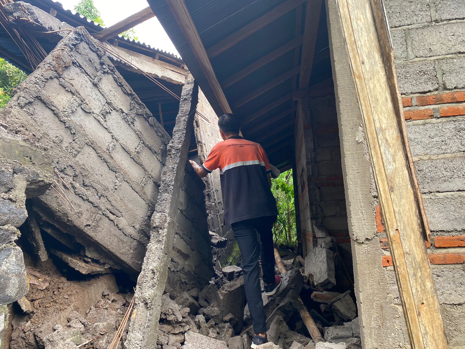 TIMBUN BALITA: Tembok rumah di Banjar Dinas Babakan, Desa Sambangan, Kecamatan Sukasada, jebol menimbun seorang balita. Syukurnya balita itu berhasil selamat.