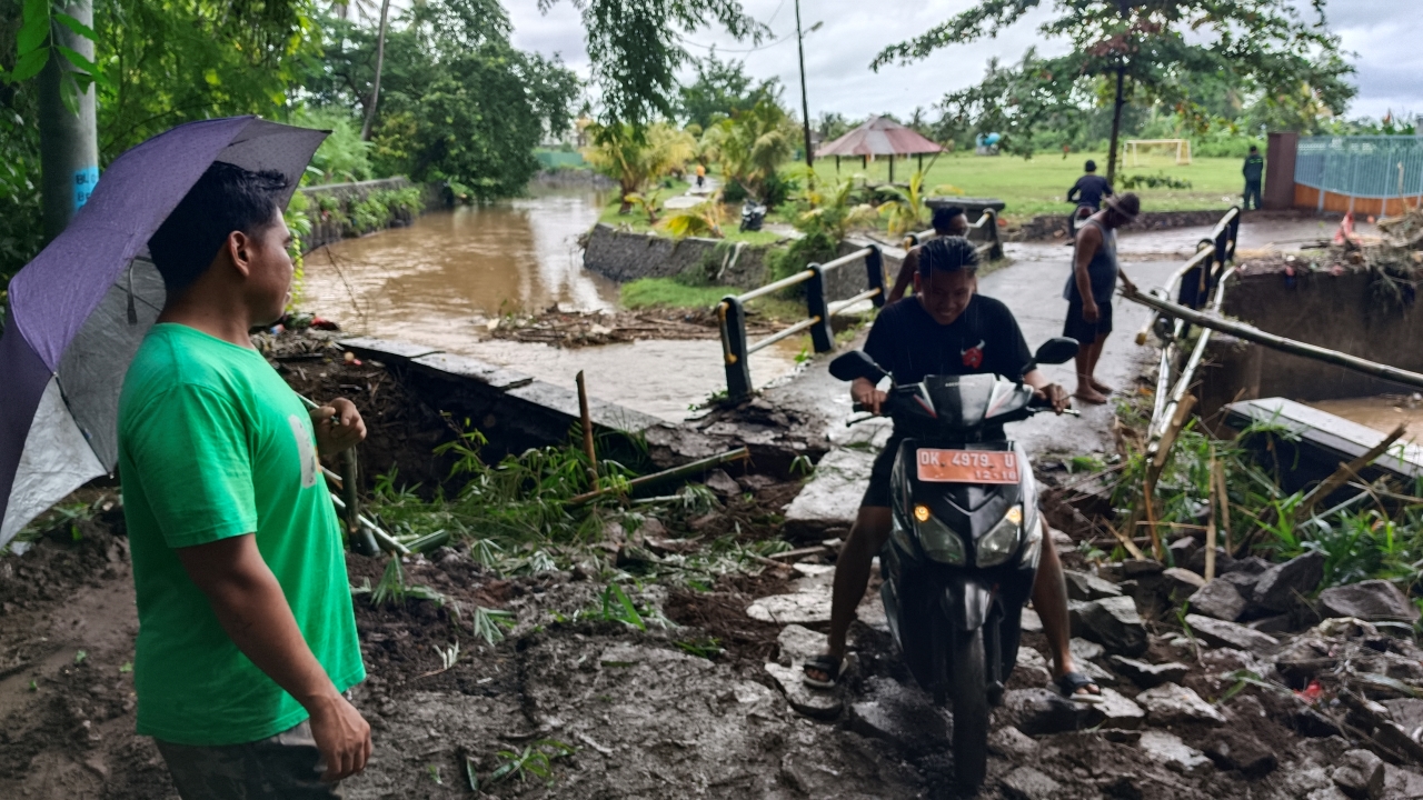 AKSES DARURAT: Warga melintas di Jembatan Celuk Buluh setelah dilakukan perbaikan darurat.