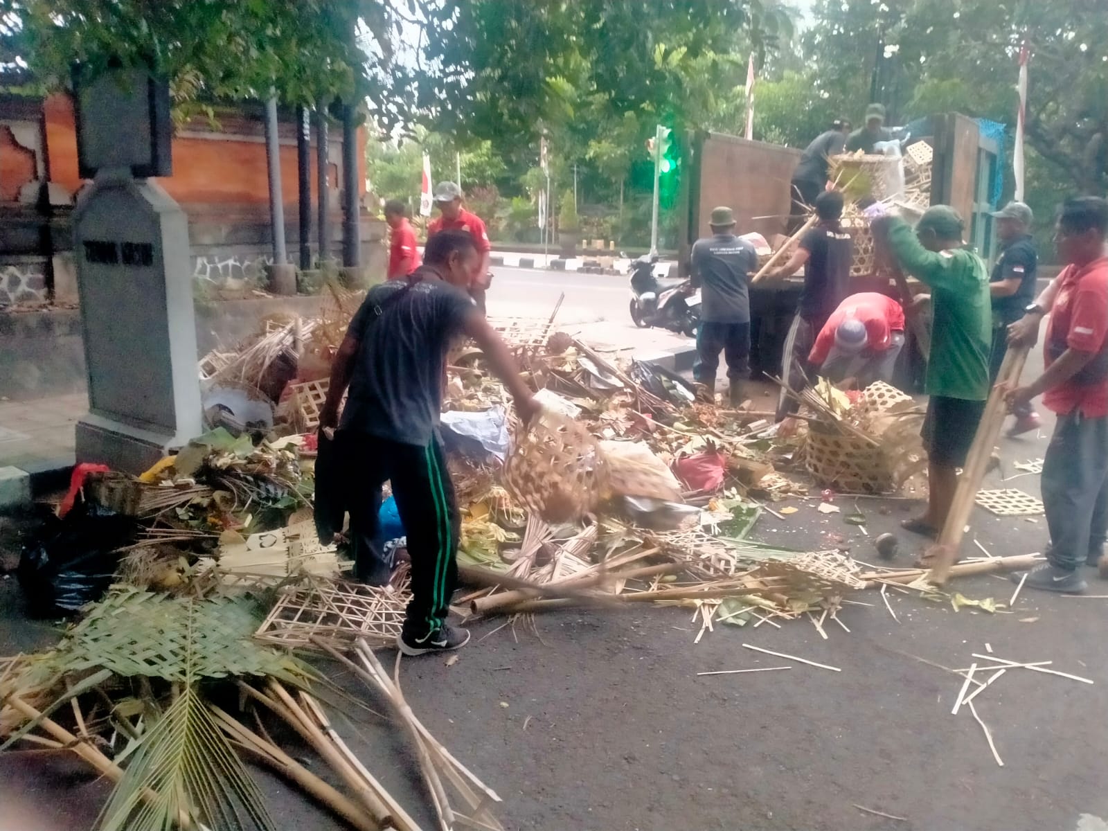 BERSIHKAN SAMPAH: Petugas DLH Buleleng membersihkan tumpukan sampah sisa upakara di Jalan Veteran, Singaraja.