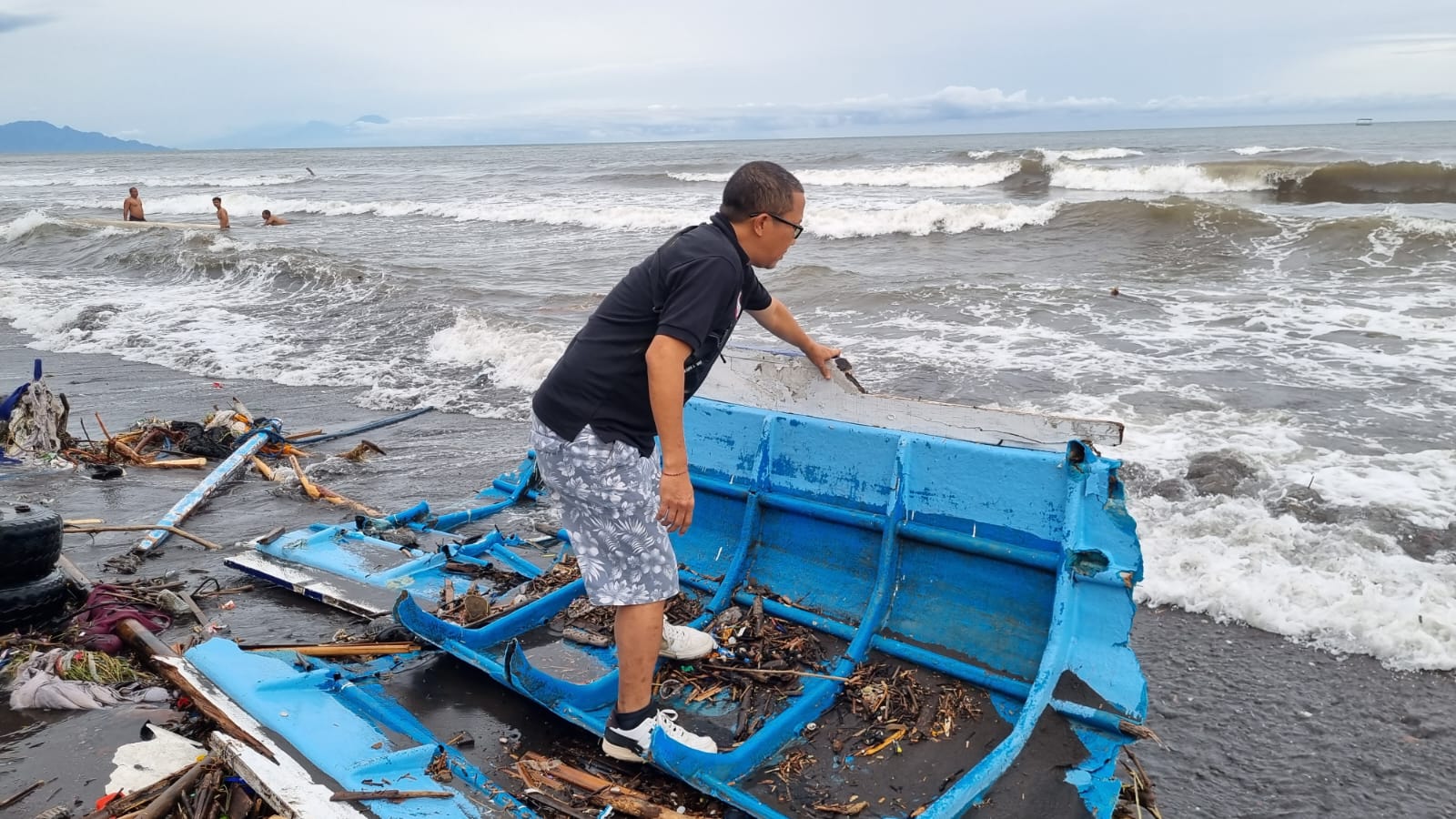 PECAH: Salah satu perahu milik nelayan di Pantai Camplung yang pecah disapu gelombang pasang.