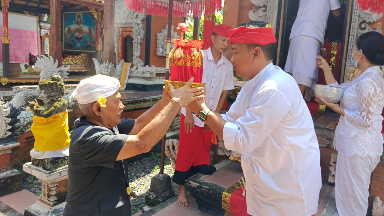 AIR SUCI: Kelian Desa Adat Buleleng, Nyoman Sutrisna (kiri) saat nunas tirta wangsuh pusaka Ki Baru semang di Merajang Agung Puri Gede Buleleng.