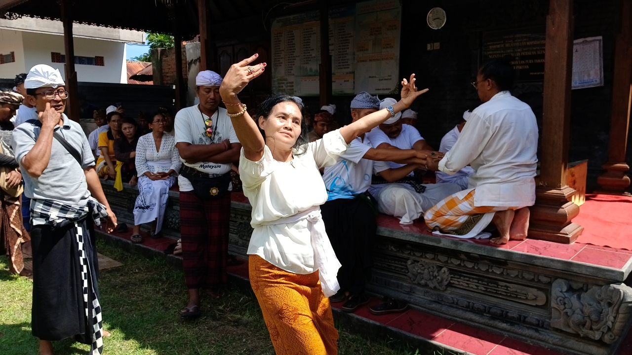 KERAUHAN: Seorang pragina mengalami kerauhan saat Dinas Kebudayaan Buleleng melaksanakan upacara guru piduka di Pura Pengaruman Banjar Paketan.