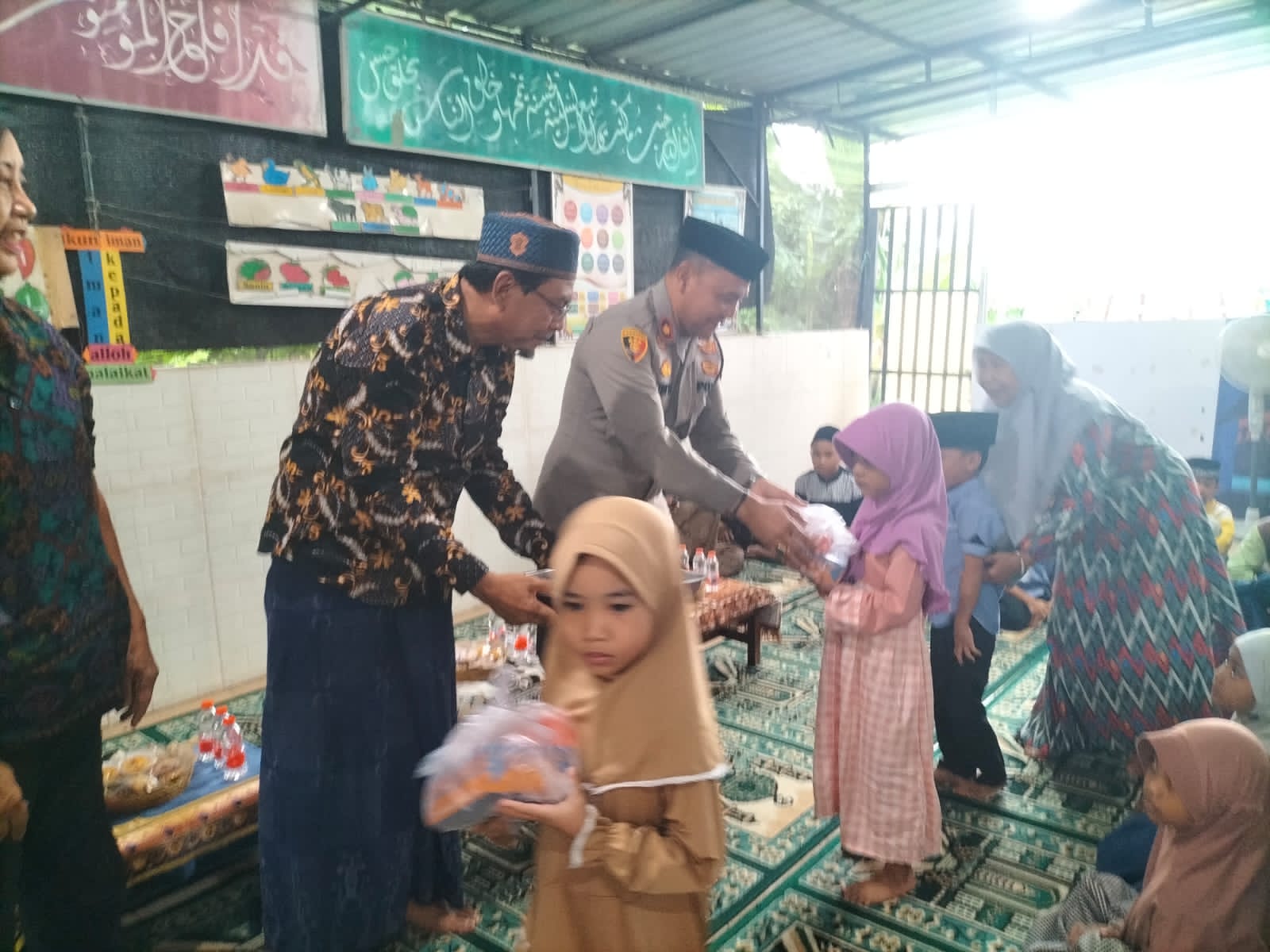 BERBAGI: Kapolsek Mengwi, Kompol Ketut Adnyana TJ saat berbagi takjil kepada santri yayasan dan warga perumahan.