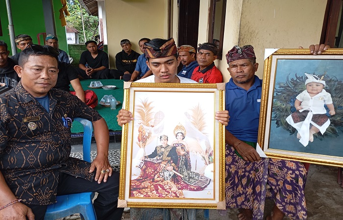 Adik dan paman korban menunjukkan foto Ari dan Novi serta anak laki-lakinya. Keluarga kecil itu menjadi korban tragis kebakaran di sebuah kost di wilayah Sesetan, Denpasar Selatan.