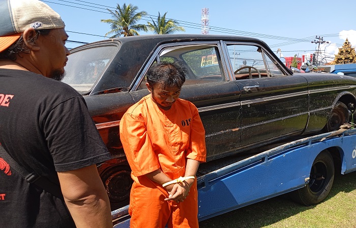 Pelaku I Gede Nova Suarbawa alias Celeng berfoto dengan barang bukti mobil yang dicurinya.