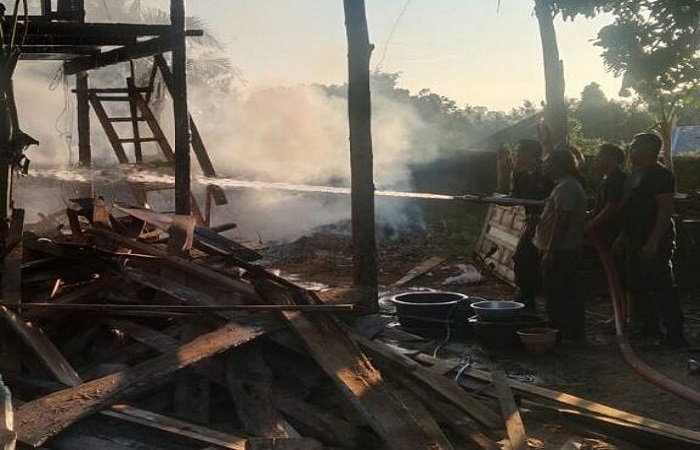 Proses pemadaman gudang limbah kayu yang terbakar.