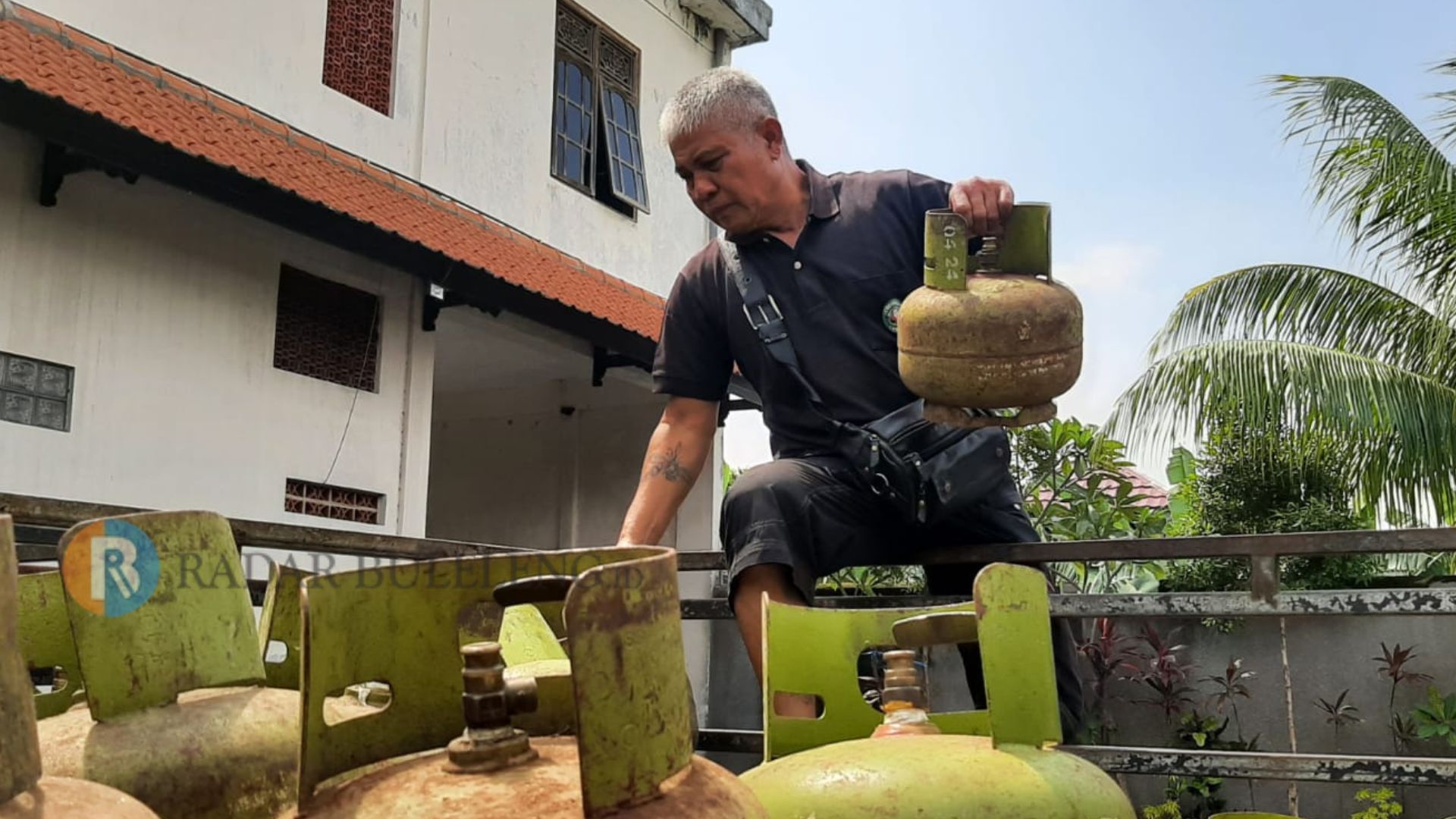 KOSONG: Salah seorang karyawan mengatur tabung gas LPG 3 kilogram yang kosong.