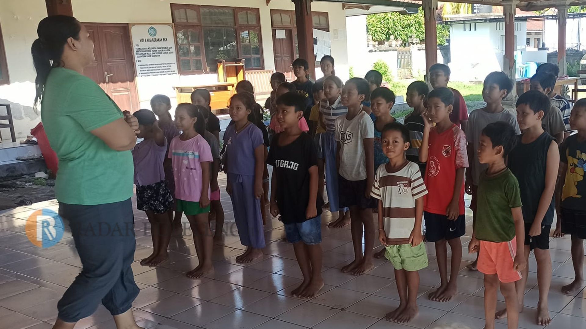MENANTI MAKAN SIANG GRATIS: Aktivitas anak-anak di Bali Desa Banyupoh pada Minggu (2/6/2024) pagi. Mereka bermain sembari menanti jatah makan siang gratis yang diberikan kepala desa.
