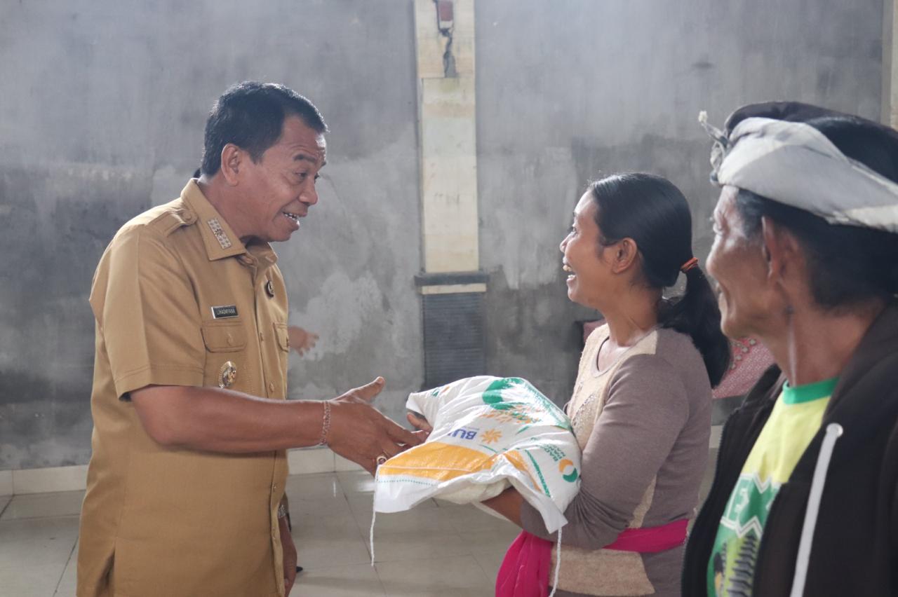 CADANGAN PANGAN: Pj. Bupati Buleleng Ketut Lihadnyana (kiri) saat menyerahkan bantuan beras kepada warga di Desa Dapdap Putih, Busungbiu.