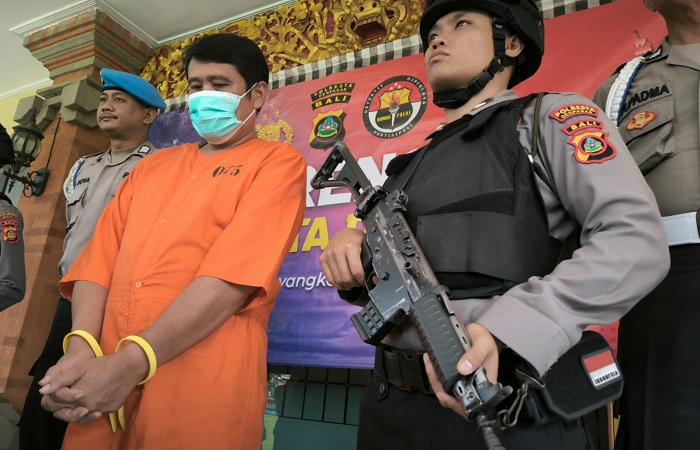 Tersangka Sukojin dikawal polisi. Dia dikenakan pasal berlapis setelag gudang gas oplosannya meledak dan tewaskan 18 pekerjanya.