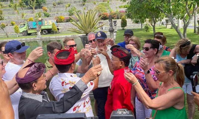 PERKENALKAN ALKOHOL KHAS BALI: Wayan Koster (berbaju merah) saat mengajak para wisatawan untuk mencoba arak Bali di Taman Soekasada Ujung, Minggu (23/6/2024).