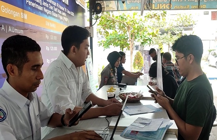 Petugas Satpas SIM Polresta Denpasar dan BPJS menyampaikan sosialisasi pemohon SIM.