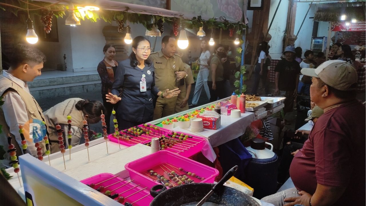 TERLARANG: Petugas dari BBPOM Denpasar dan Polisi Pamong Praja menegur penjual yang berjualan cikbul di arena PKB