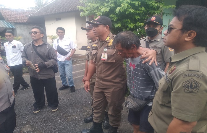Kadek Jiwa, 60, dirangkul oleh petugas untuk diajak menuju RS Jiwa Bangli.