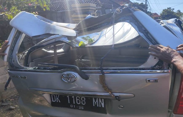 BPBD Buleleng melakukan evakuasi terhadap pohon santen yang menimpa mobil di jalur perbatasan Desa Kerobokan dan Desa Sinabun.