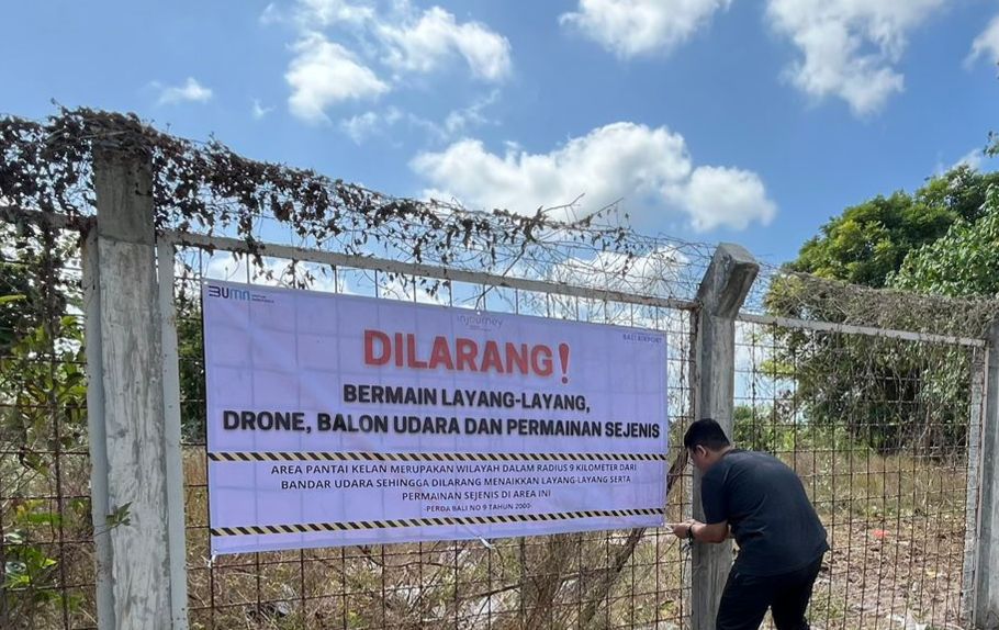SPANDUK: Satgas Layang-Layang Bali memasang spanduk himbauan larangan menerbangkan layangan maupun benda sejenisnya di sekitar Bandara Ngurah Rai.