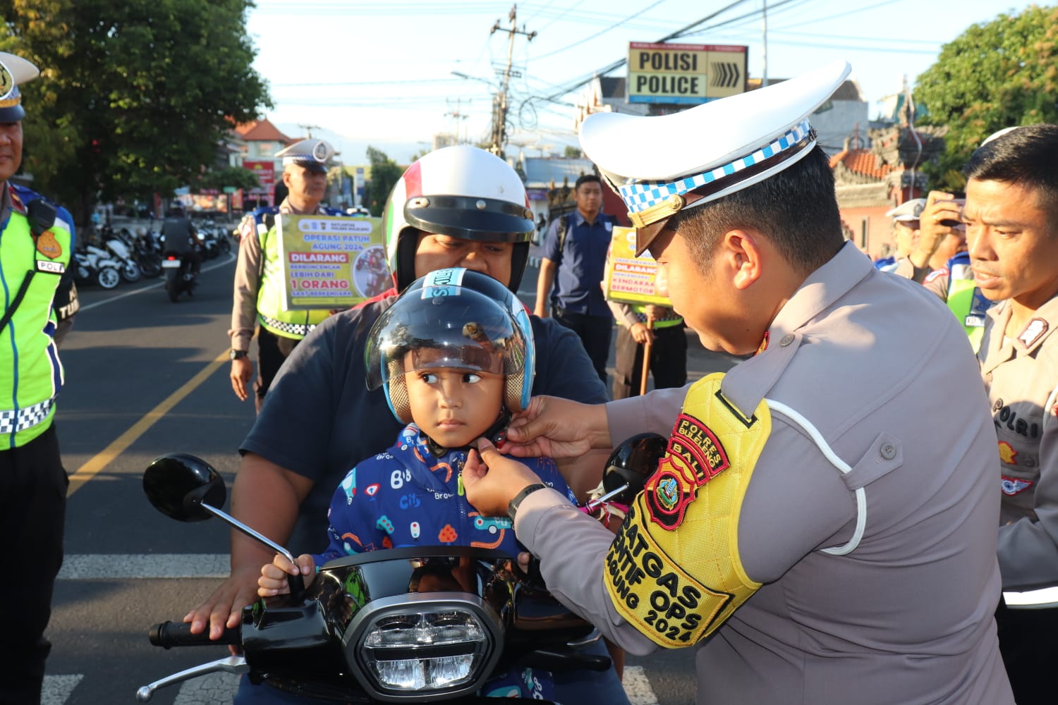 HELM GRATIS: Polisi lalu lintas Polres Buleleng membagikan helm gratis kepada anak-anak yang tidak mengenakan helm.