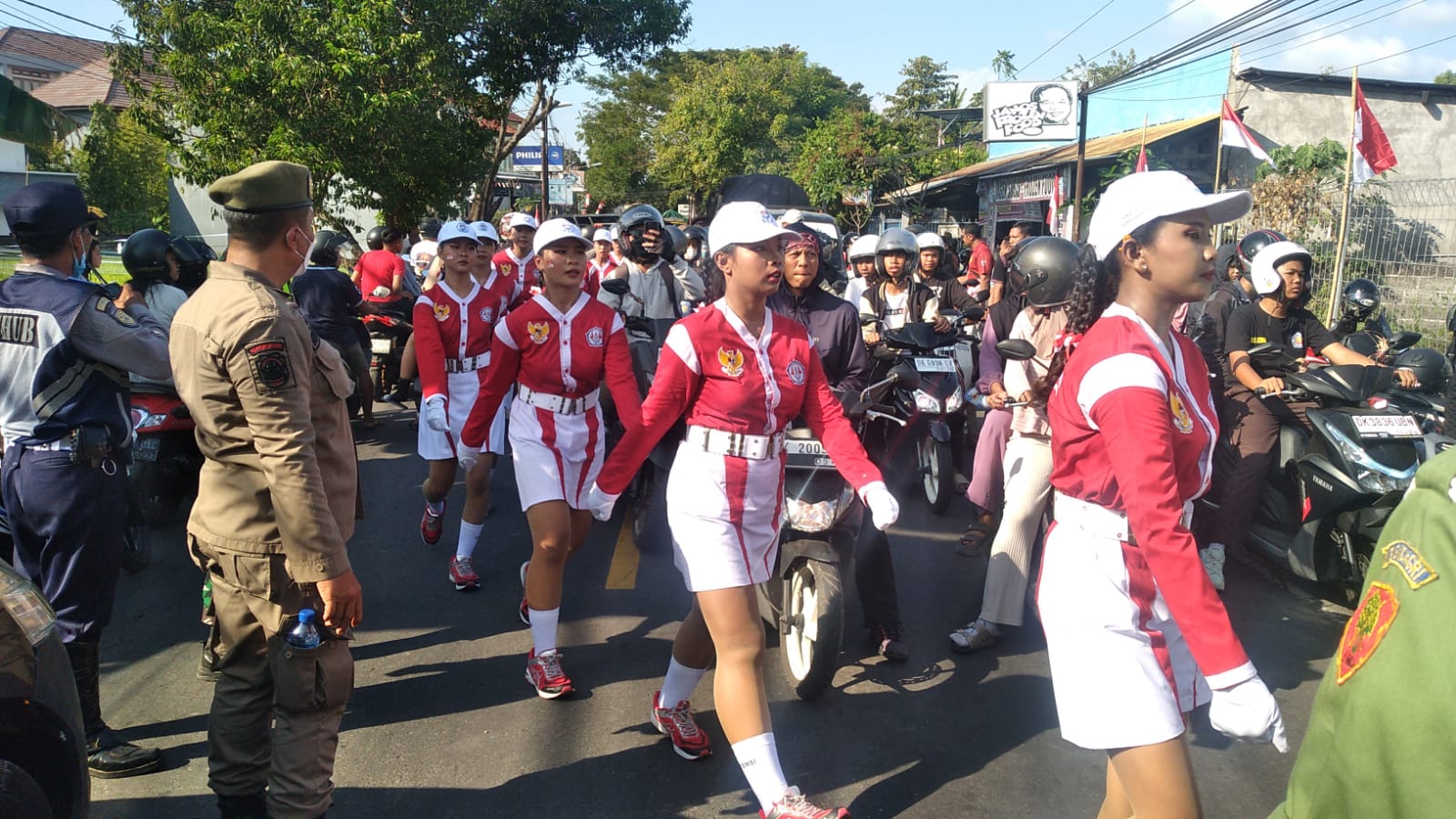 TERJEBAK MACET: Peserta lomba gerak jalan 17 kilometer putri di Buleleng terjebak macet. Dampaknya tim tersebut harus mengakhiri rute Etape I dengan satu barisan memanjang.