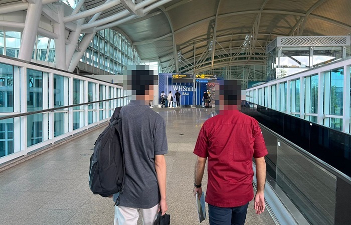 JHH (kiri) dideportasi Imigrasi Singaraja akibat overstay selama 109 hari di Indonesia. Ia datang ke Kantor Imigrasi Singaraja dan diketahui sudah overstay, akhirnya harus dikembalikan ke negaranya.