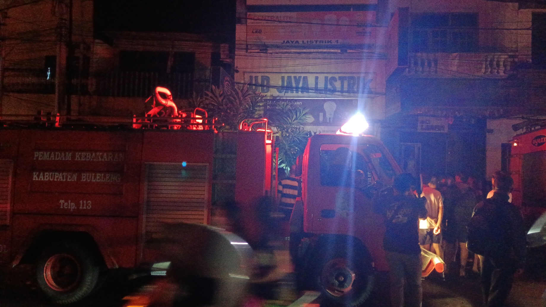 KEBAKARAN: Petugas pemadam kebakaran berusaha menjinakkan api yang membakar toko listrik di komplek Pasar Anyar Buleleng.