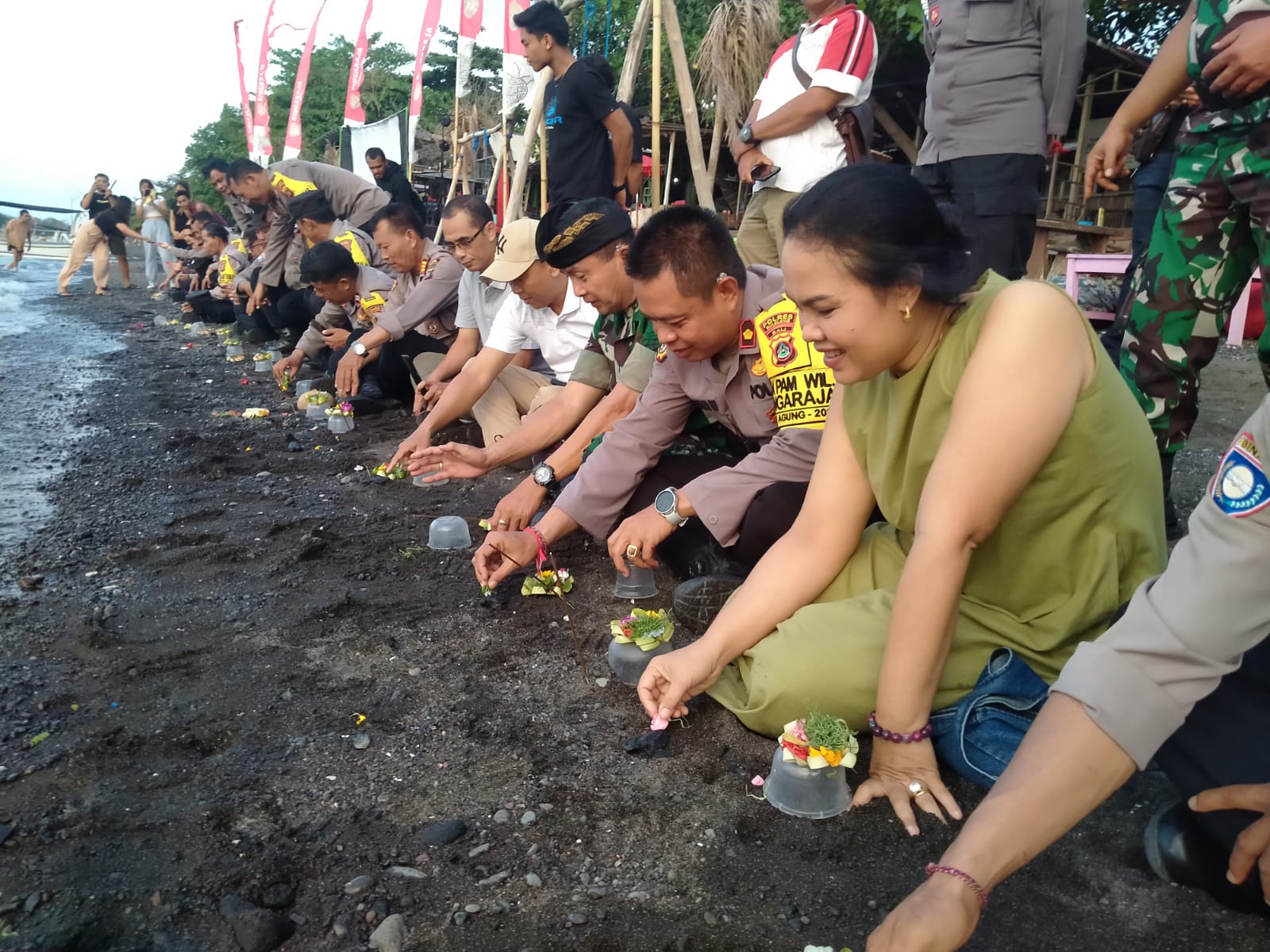 MENJAGA ALAM: Proses pelepasan tukik yang dilakukan personel Polsek Kota Singaraja di Pantai Penimbangan, Buleleng.