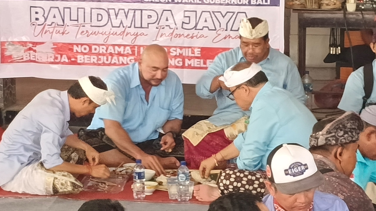 MEGIBUNG: Made Muliawan Arya alias De Gadjah (kiri) saat megibung dengan masyarakat di Desa Sumberkima, Buleleng.