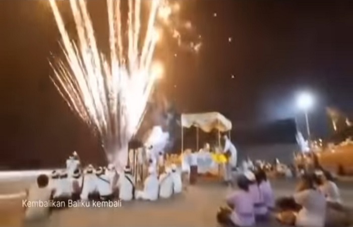 Tampak kembang api meletus saat umat Hindu melakukan ritual keagamaan di Pantai.