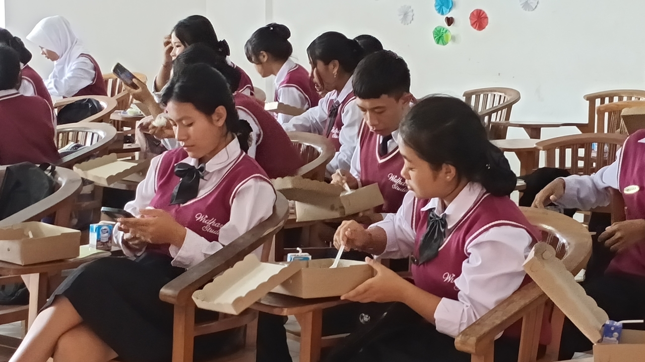 MAKAN SIANG: Siswa di SMK Widya Dharma Bali atau SMK Widarba menikmati paket makan siang bergizi.
