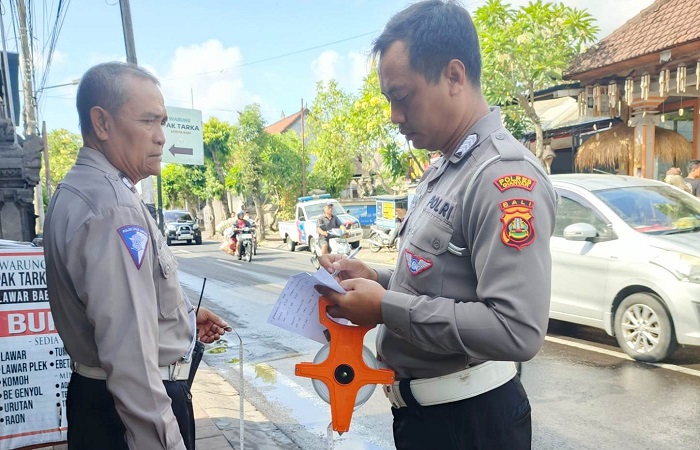 Petugas Satuan Lantas Polres Gianyar saat berada di lokasi kejadian kecelakaan antara motor dan truk tangki BBM.