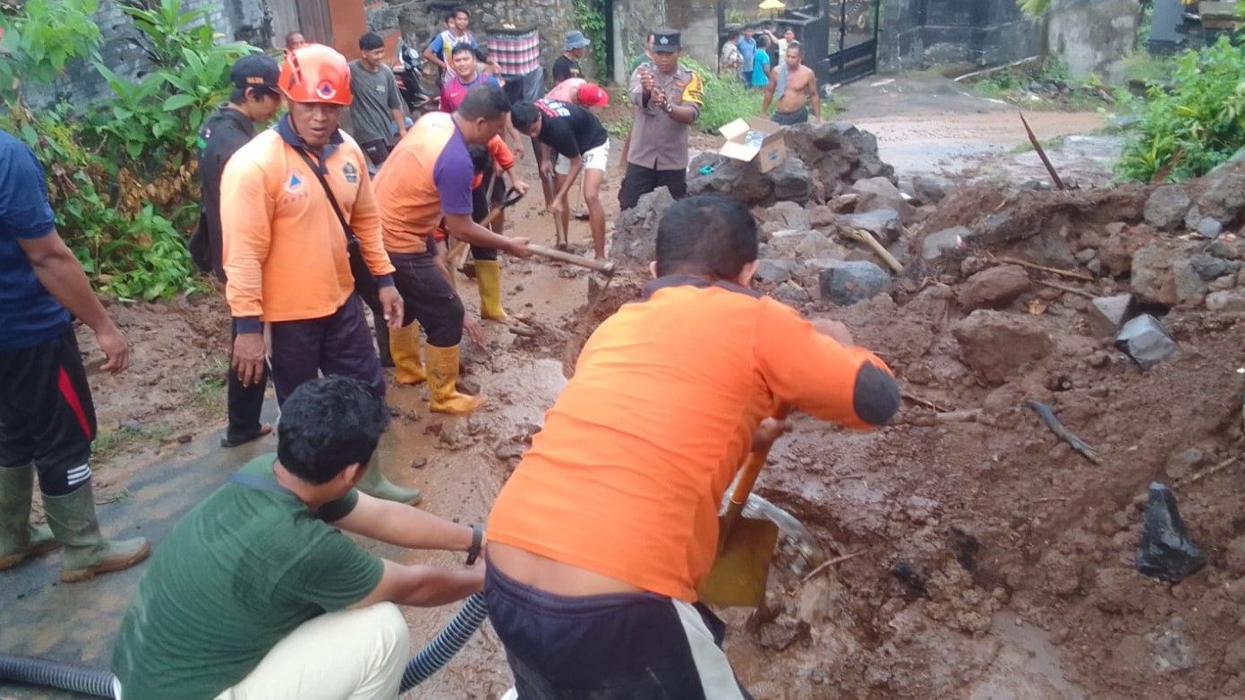 LONGSOR: Tim Reaksi Cepat BPBD Buleleng membersihkan material longsor di Desa Alasangker.