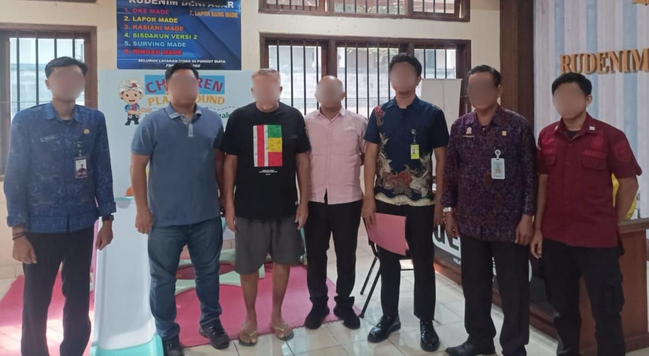 BERULAH: WNA asal Belanda (pakai celana pendek) saat diserahkan ke Rudenim Denpasar. Dia kerap mencaci maki warga lokal.